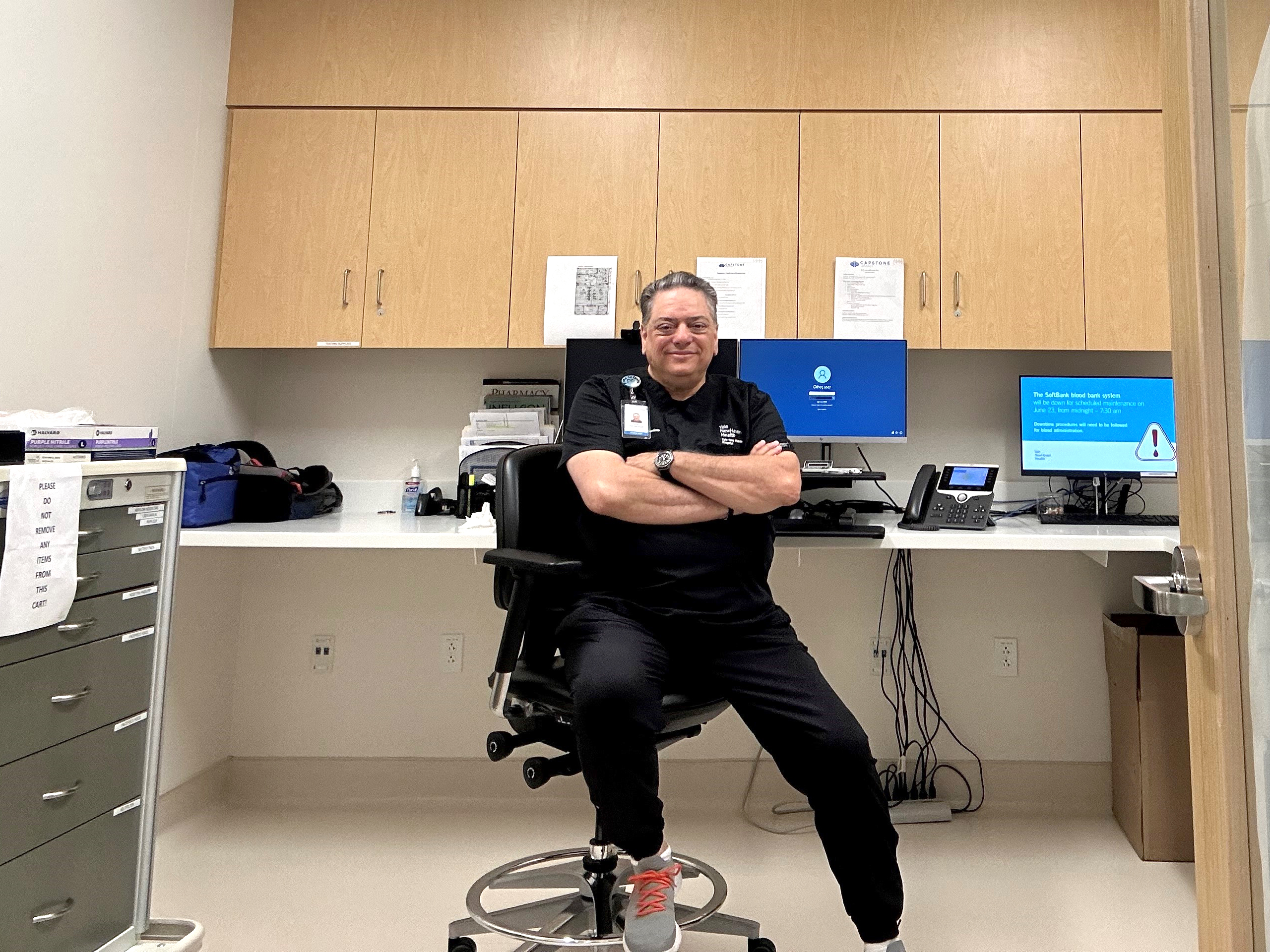 Gene B. Decaminada in his office, sitting down with his arms crossed.