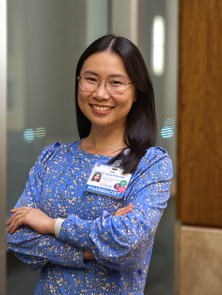 Pharmacist Yujing Steenwyk is smiling - blue blouse with a hospital badge.